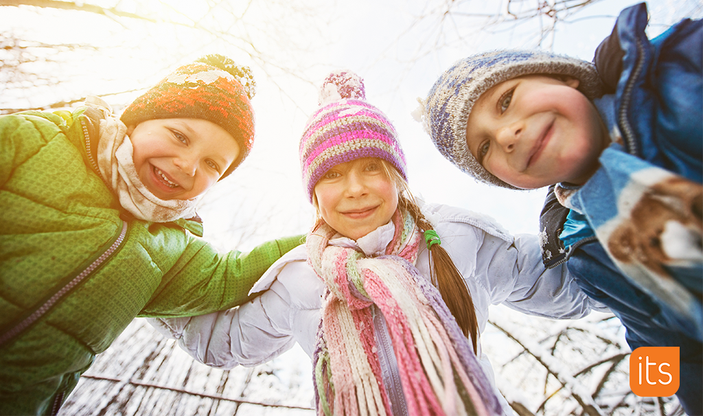 trois enfants souriant, dehors dans la neige